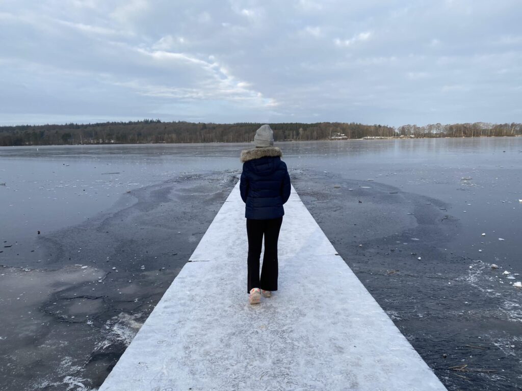Pige går ud på badebro ved en tilfrosset Økssø