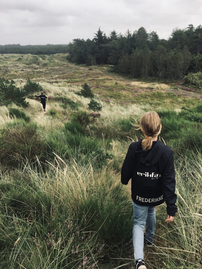 To piger på vej ned ad bakke i hedelandskab
