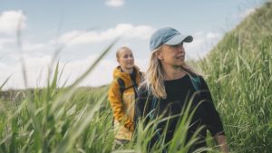 To kvinder går gennem sivene ved kysten