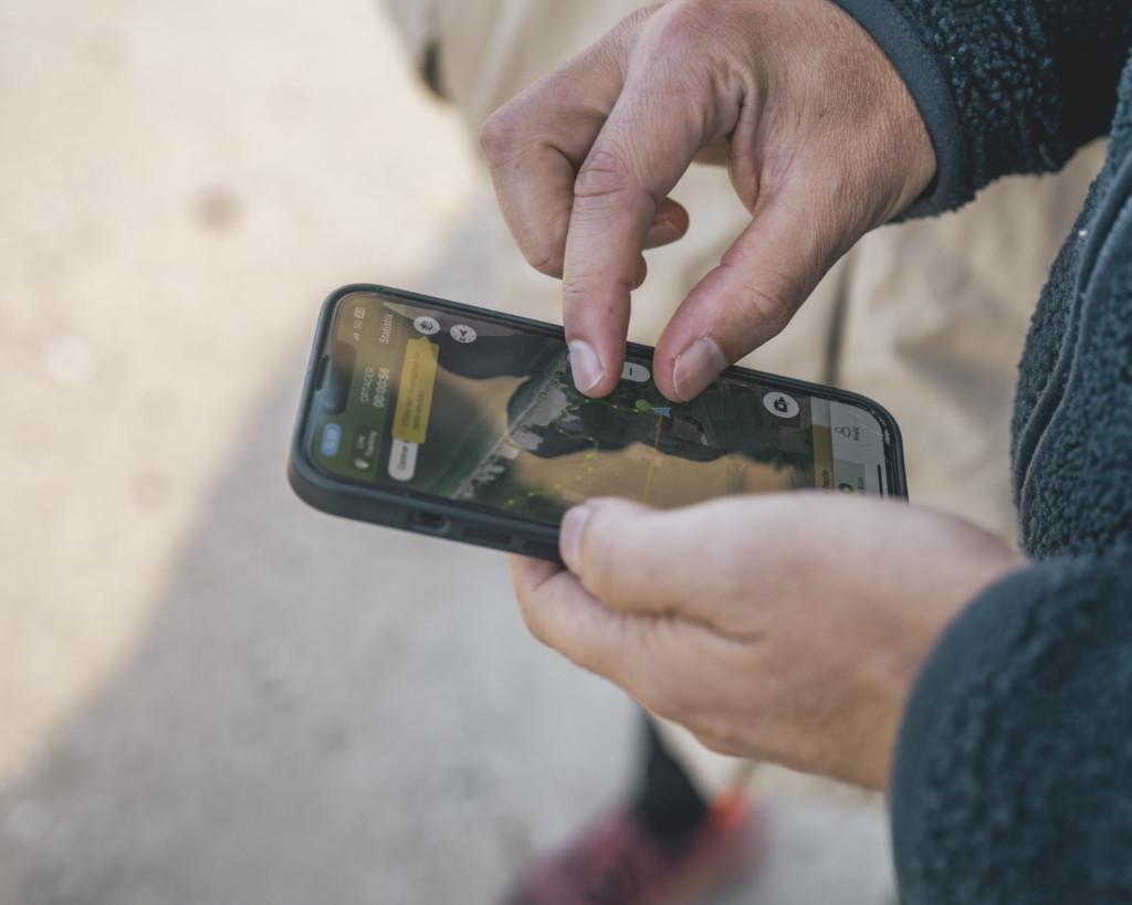 Mand står med wikiloc åben på sin telefon og kigger på ruten